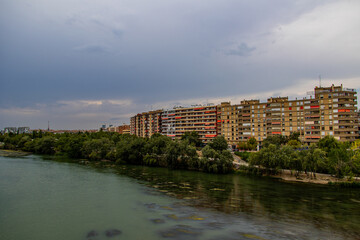 Fototapeta na wymiar lof the Ebro river and apartment blocks in Zaragoza, Spain on a cloudy summer day