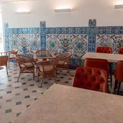 An antique Portuguese cafe in Lisbon by the pier with art azulejo tiles and patterns with chairs and tables