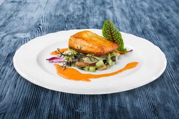 fried fish fillets on a plate on a wooden table
