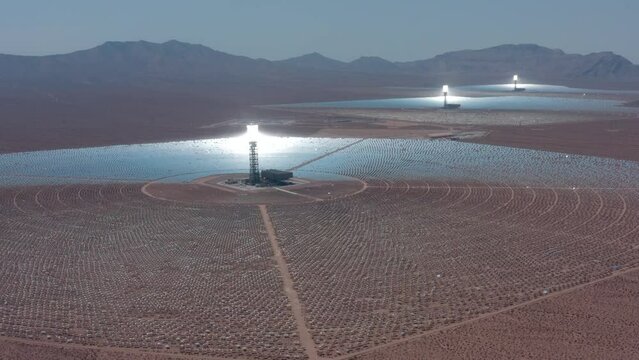 Aerial view of solar thermal plant. Large circular power plant of solar panels. Alternative energy solar power farm creating electricity in open desert field.  Solar panels field (solar cell). 4K