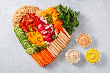 Colorful vegan Charcuterie board with raw vegetables and whole wheat snacks