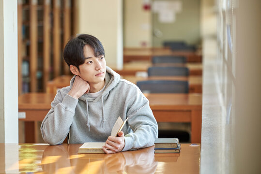 아시아 한국의 대학교 도서관에서 다양한 자세로 책을 보고있는 젊은 대학생 남자 모델