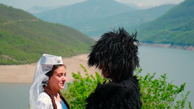 A girl and a man in a papakha and national Georgian costume. Selective focus.