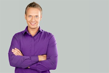 Portrait of smiling mature man standing and posing on background.