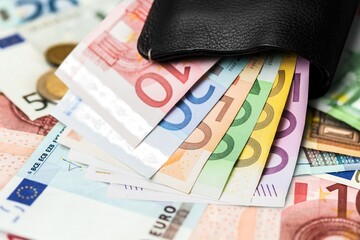 Background of banknotes and euro coins of different denominations on the desk