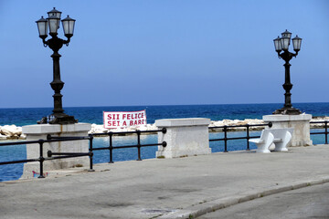 Messaggio impresso sullo striscione campeggiato sugli scogli. Lungomare di Bari. Sud Europa