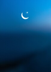 Naklejka na ściany i meble Crescent moon and star on dusk sky in the evening, religion of Islamic begin Ramadan month
