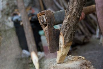 Ax cutting wooden stake outdoor in village yard. Close up, selective focus