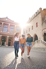 Vertical photo of Fantastic time spent with best friends. Three happy girls having fun outdoors in...