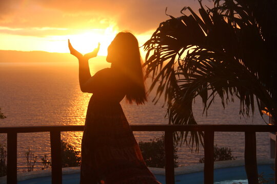 woman catching sunrise on her hands