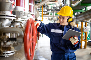 An experienced refinery or factory worker checking pressure of gas pipes.