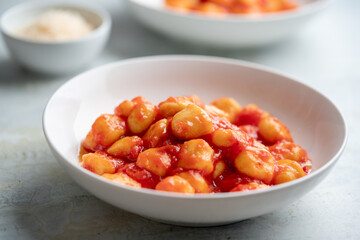 Gnocchi with tomato sauce and parmigiano on a plate