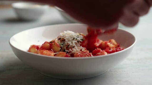 Gnocchi with tomato sauce and parmigiano on a plate
