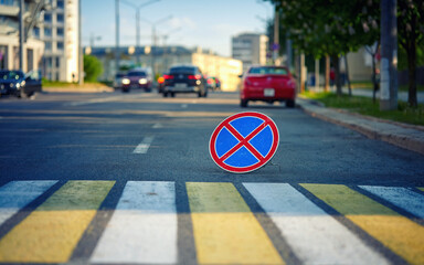 No parking road sign, road sign stands on asphalt road behind pedestrian crossing. No parking and...