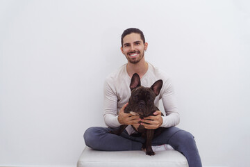 Man on a white background smiling with his dog