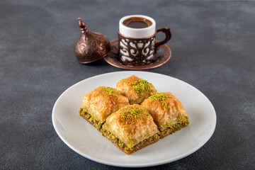 Pistachio baklava on a white plate with Turkish coffee
