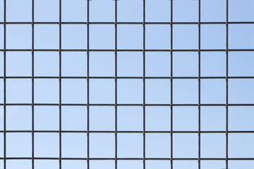 Metal grid in the form of a grid on a blue background