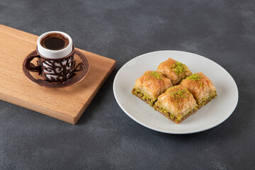 Pistachio baklava on a white plate with Turkish coffee