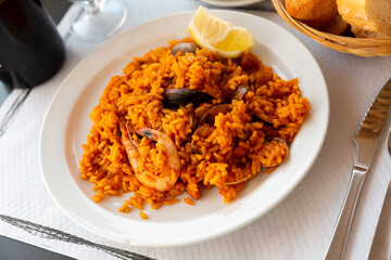 Spanish paella with prawns, calamari and mussels on white plate