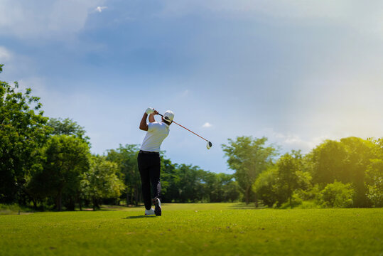 Asian man golfing on the course. In summer