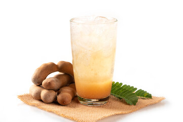 Glass of tamarind juice with tamarind fruits and leaves on white background.