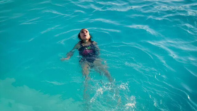 The child swims in the pool. Selective focus.