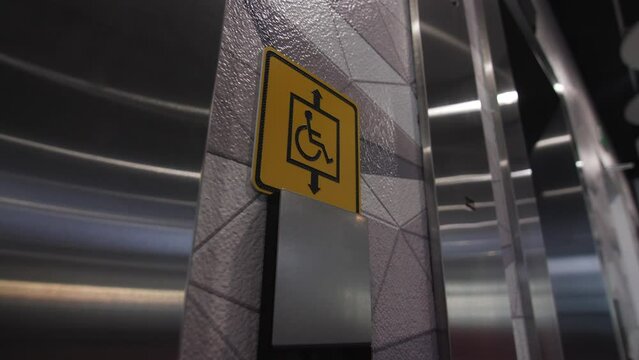 Electric vehicle charging station sign on city street and elevator for disabled passengers in business center closeup