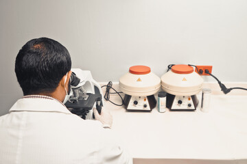 Laboratorian examining a blood sample from behind in a microscope in a hospital in Managua Nicaragua