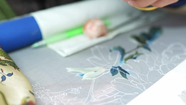 chinese female intangible culture heritage artist stitching on cloth
