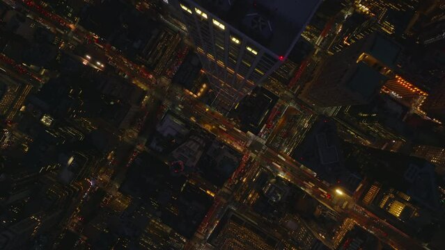 Aerial birds eye overhead top down footage of downtown at night. Fly above tall modern apartment skyscraper. Manhattan, New York City, USA