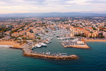 Fototapeta na wymiar Scenic aerial panoramic view of modern Frejus cityscape on Mediterranean coast with sandy beach and marina on summer day, Var department, France