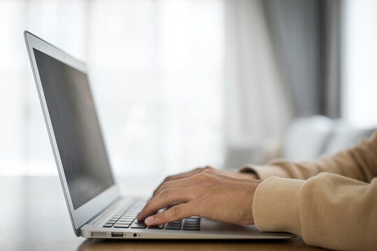 Student studying online training course at home. Young man of Asian ethnicity watching a webinar on online education using a laptop. Studying online is convenient and can be studied anywhere.