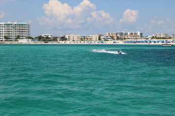 speedboat moving quickly through the ocean along the coastline