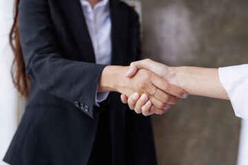Obraz premium Business handshake for teamwork of business merger and acquisition,successful negotiate,hand shake,two businessman shake hand with partner to celebration partnership and business deal concept