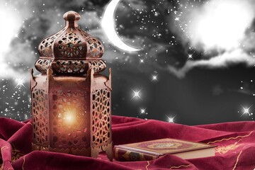 Ornamental Arabic lantern with burning candle glowing at night. Festive greeting card, Muslim holy month Ramadan Kareem.