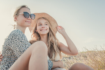 Czech teenagers girlfriends couple enjoy the sunset at a Spanish beach during summer vacations....