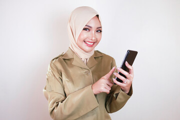 Smiling government worker showing blank screen on a smartphone. A young Asian Muslim PNS wearing...