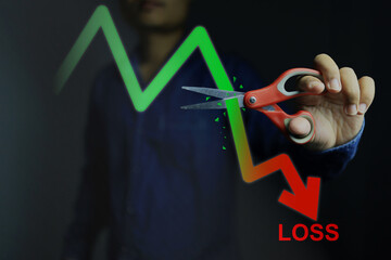 Fototapeta Investors decide to use scissors to cut or eliminate the loss portion of the red chart to maintain costs or prevent further losses in the stock market. cut loss concept. obraz