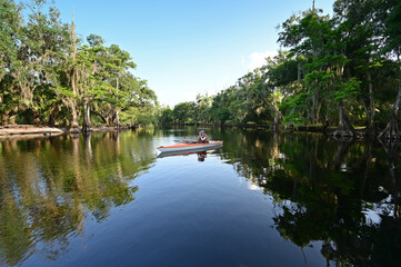 Woman kayaking on Fisheating Creek near Palmdale, Florida on calm summer afternoon.