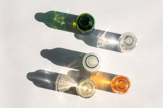 A glass bottles with oil or serum with beautiful shadows from the morning sun Natural Organic Spa Cosmetic concept. . Front view. High quality photo