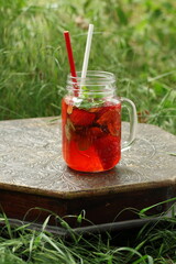 Homemade lemonade with strawberries and mint in the yard at the cottage
