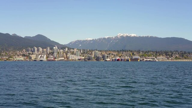 Taking the sea bus ferry on Vancouver Harbour. Downtown North Vancouver skyline in the background. British Columbia, Canada.