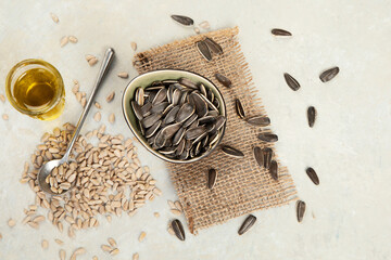 Sunflower oil and sunflower seeds on light background.