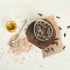 Sunflower oil and sunflower seeds on light background.