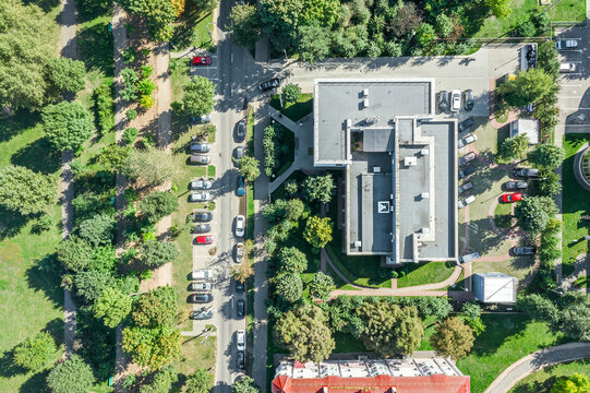 aerial top view of a small business building among green trees in residential area