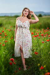 Beautiful plus size woman in a poppy field