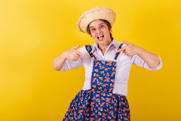 Mature woman dressed in typical Festa Junina clothes. Inviting, Sign here, only here, is here.