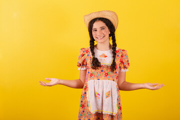Girl wearing traditional orange clothes for festa junina. With open arms, welcome, welcoming.