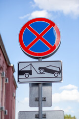 The road sign prohibits stopping against the background of buildings and cars. Close-up road signs...