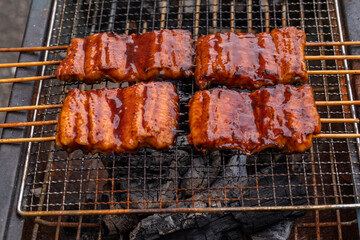 網で焼かれる鰻　eel